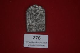 German historical commemorative badge depicting a town scene beneath a portrait medallion, dated