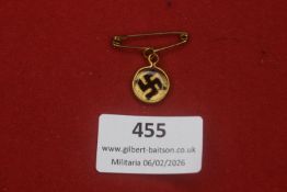 Third Reich small swastika pendant badge, gilt-tone frame with central black swastika under clear