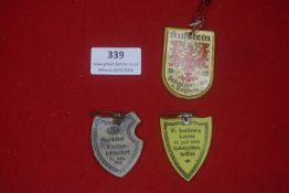 A small group of German cardboard and celluloid event badges, including shield-shaped examples dated