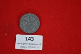 German shooting association tinnie, circular form with central wheel motif and surrounding