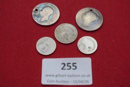 Group of five small silver coins, including a holed Victorian shilling and other worn pieces.