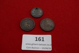 Group of Victorian bronze coins including two farthings (1860 and 1886) and a half farthing/token