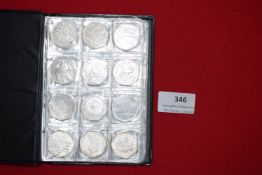 Album of UK commemorative 50p coins including Olympic and Beatrix Potter types, housed in folder.