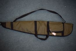 Green canvas rifle slip with black trim, carry handles, shoulder strap and external pocket.