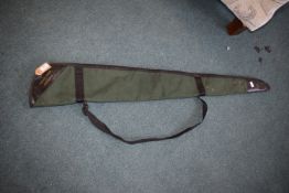 Green canvas gun slip with black leather end caps, marked “The Gun Keeper from Parker-Hale”, with