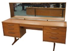 An Austin Suite teak dressing table, with rectangular plain mirror, raised above six pedestal