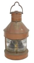 A copper masthead ship's lantern, with a swing handle and masthead plaque, above a further plaque