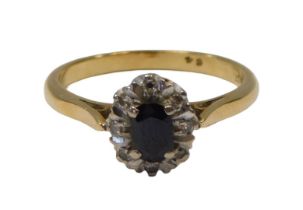 A sapphire and diamond cluster ring, the oval sapphire in a four claw setting, surrounded by a