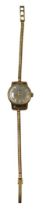 A 9ct gold Omega lady's wristwatch, the silvered batoned dial, 1.8cm wide, on a snake link bracelet,