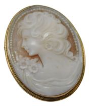 A late 20thC shell cameo brooch, the oval cameo depicting a maiden with curled hair and flowered