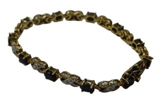A sapphire line bracelet, set with eleven oval cut sapphires and eleven cross sections, each set