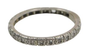 An eternity band, set with white stones, each in claw setting, on a white metal band, unmarked,