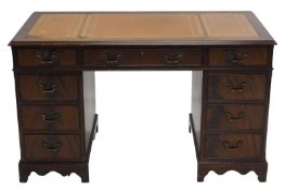 A late 20thC twin pedestal desk, with three part tooled leather top, raised above three frieze