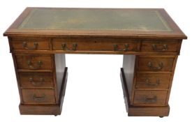 An early 20thC oak twin pedestal writing desk, the one piece tooled leather top raised above three