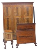 An early 20thC walnut and mahogany three piece bedroom suite, comprising triple door wardrobe raised