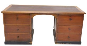A 20thC mahogany twin pedestal writing desk, with one piece crimson leather top, raised above two