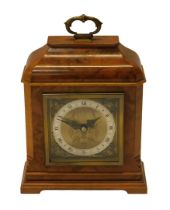 An Elliott mantel clock, in a figured walnut case, with square brass dial and silvered chapter ring,