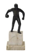 An early 20thC bronze patinated figure of a man with a bowling ball, on a marble plinth, 23cm high.