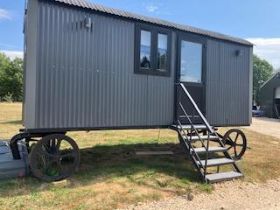 V An ex-demonstration shepherd's hut, with PVC doors and double-glazed windows, a small kitchen,