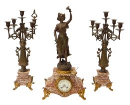 A late 19thC French three-piece figural clock garniture set, within a rouge marble case having
