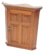 A 20thC Georgian style walnut hanging corner cupboard of small proportion, with panelled door
