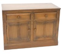 A late 20thC Ercol low side cabinet, of rectangular form, the studded top raised above two frieze
