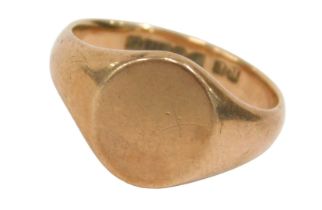 A 9ct gold signet ring, the oval ring head of plain design, on a rose gold band, ring size Q½, 5.