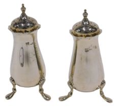 A pair of Edward VII silver pepper pots, each with urn finials, pierced domed removable lids,