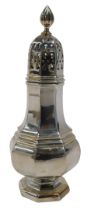 A George V silver sifter, of octagonal form, with flame finial, pierced domed lid, shaped bellied
