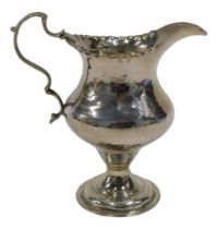 A George III silver cream jug, with plain spout, flared rim, acanthus leaf ear shaped handle,
