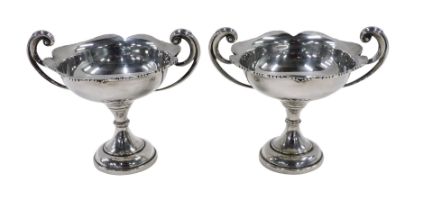 A pair of late Edward VII silver bonbon dishes, each with scroll handles, flared floral rims,