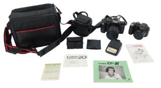 A Canon EM-M SLR camera, in a canvas case, together with a Fujifilm Finepix S camera, cased, with