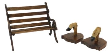 A miniature doll's bench, with cast metal end supports and a slatted seat and back, 24cm wide,
