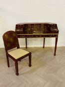 A contemporary Chinese chinoiserie style lacquered Carlton House desk with a matching desk chair,