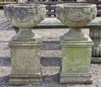 Haddonstone - Pair of weathered reconstituted stone garden urns with grape vine relief, raised on