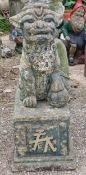 Reconstituted stone statue of a Foo dog raised on a plinth with gilded relief, H 80cm x W 33cm x D
