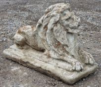 Reconstituted stone statue of a recumbent lion, H 47cm x W 31cm x D 70cm