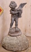 Lead water feature of a boy holding a duck raised on a weathered natural stone domed plinth, H