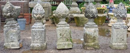 Set of five weathered reconstituted stone pineapple finials raised on square cut plinths with