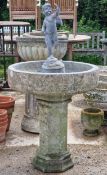 Weathered reconstituted stone bird bath with lead lined bowl raised on an octagonal column,