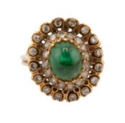 A Continental emerald and diamond oval cluster ring, centred with an oval cabochon emerald approx.