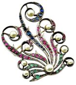 An early 20th century multi-gem brooch in the form of looping leaf scrolls set with graduated