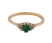 A modern 9ct gold, emerald and diamond dress ring, centred with a small oval mixed-cut emerald