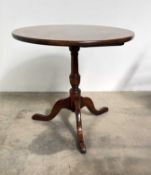 A 20th century oak tilt top tripod table in the early 19th century style, a circular tilt top over a