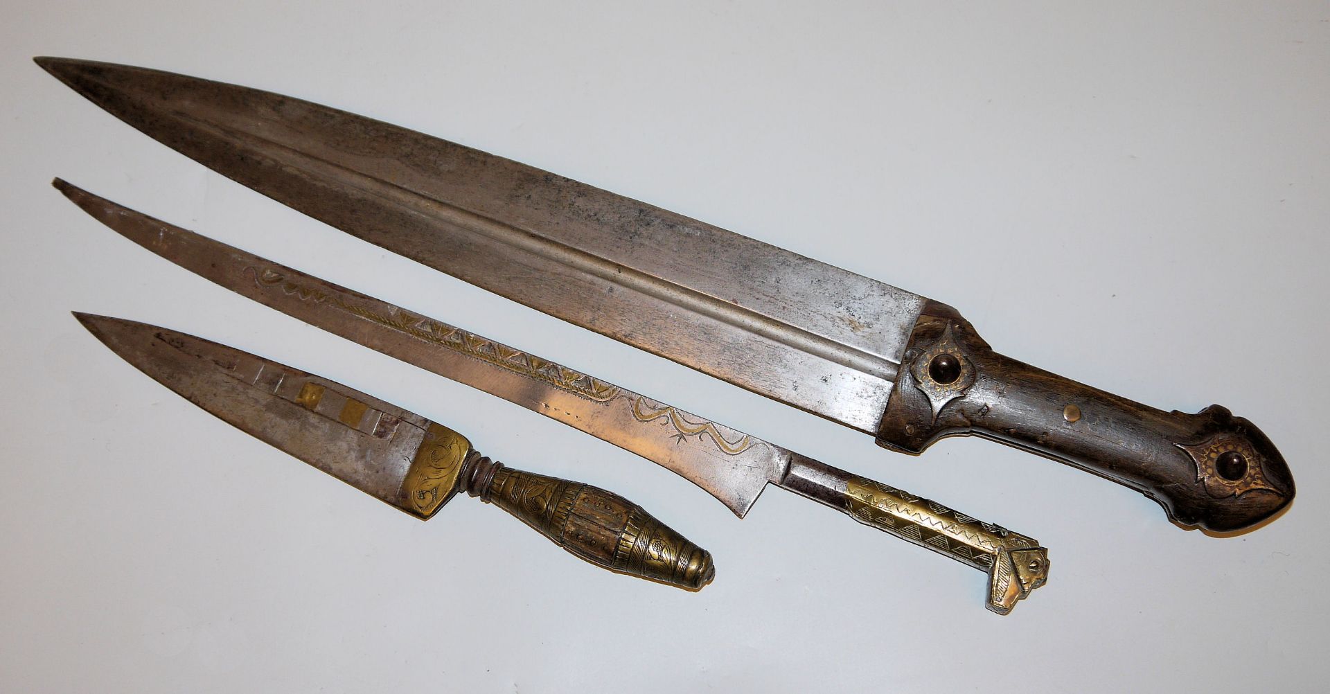 Ein kaukasischer Kindjal, eine algerische Flyssa und ein spanischer Puñal, drei Blankwaffen, alle 1