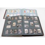 Two Edwardian cigarette card albums containing 'Time and Money in Different Countries' c1908 (part