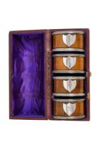 A set of four oak and silver plate mounted napkin rings - featuring shields engraved with letters,