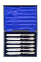 A boxed set of six silver handle fruit knives - Birmingham 1912, with floral repousse decoration.