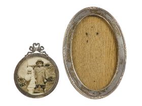 A silver photograph frame - Birmingham 1906, circular and surmounted with a bow, aperture 6.5cm,