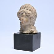 Terracotta bust of a female head, mounted on a black base